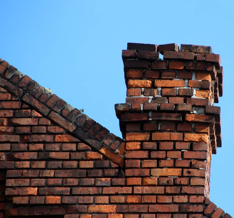 Signs Your Owings Mills Home Needs a Chimney Inspection Blog Article - Damaged chimney on an Owings Mills home showing cracks and missing mortar